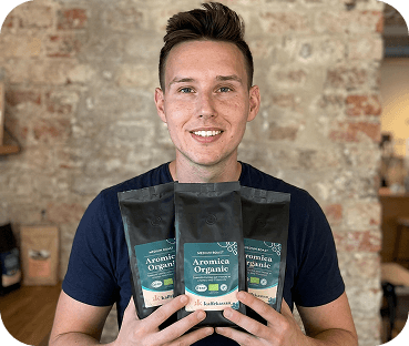 Säljare håller tre påsar Aromica Organic